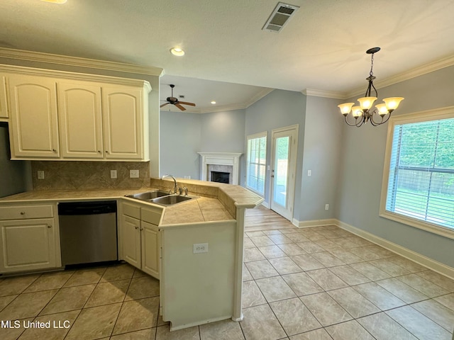 kitchen featuring stainless steel dishwasher, sink, kitchen peninsula, and a healthy amount of sunlight