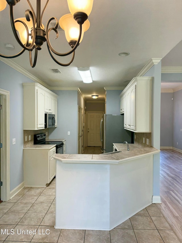 kitchen featuring crown molding, white cabinets, tasteful backsplash, and stainless steel appliances