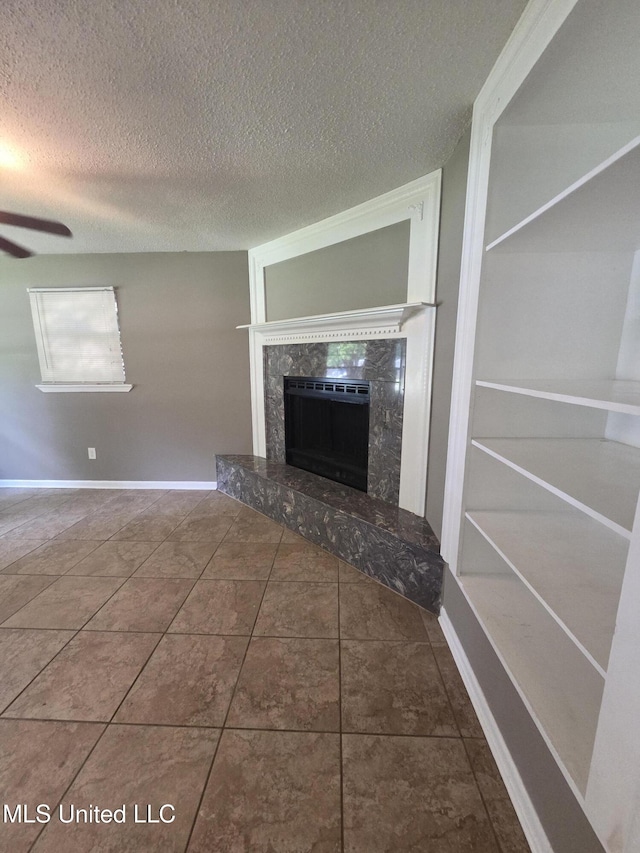 1442 Tally Ho Cir, Gulfport, MS 39507 - unfurnished living room featuring a textured ceiling, a premium fireplace, a ceiling fan, and tile patterned flooring