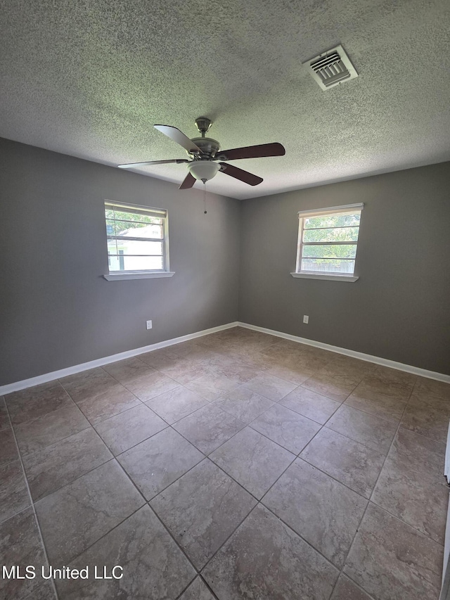 1442 Tally Ho Cir, Gulfport, MS 39507 - unfurnished room with healthy amount of natural light, ceiling fan, a textured ceiling, and tile patterned flooring