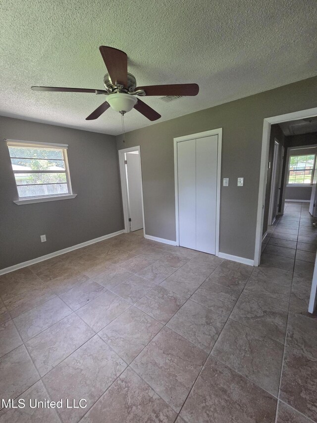 1442 Tally Ho Cir, Gulfport, MS 39507 - unfurnished bedroom featuring a textured ceiling, a closet, and a ceiling fan