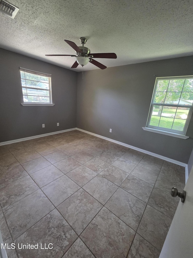 1442 Tally Ho Cir, Gulfport, MS 39507 - empty room with ceiling fan, healthy amount of natural light, a textured ceiling, and tile patterned flooring
