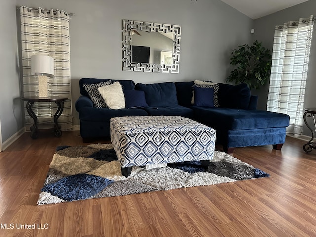 living room featuring dark wood-type flooring and vaulted ceiling