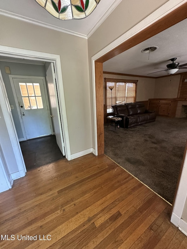 hall featuring baseboards, a healthy amount of sunlight, ornamental molding, and wood-type flooring