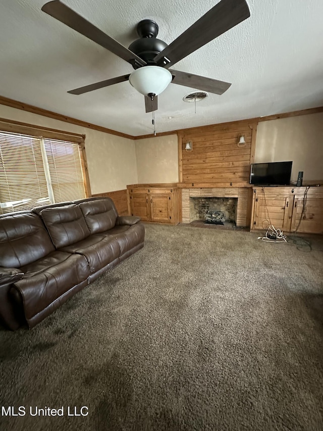 living area featuring wooden walls, carpet floors, a ceiling fan, and ornamental molding