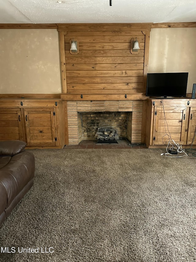 living room featuring a fireplace with flush hearth, carpet, and a textured ceiling