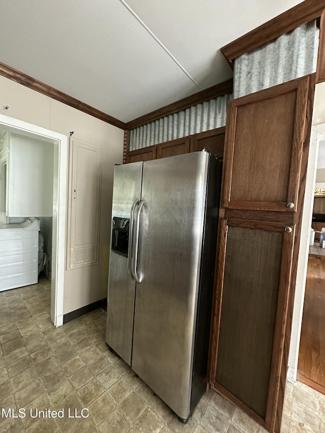 kitchen featuring washer / dryer, crown molding, baseboards, and stainless steel fridge with ice dispenser