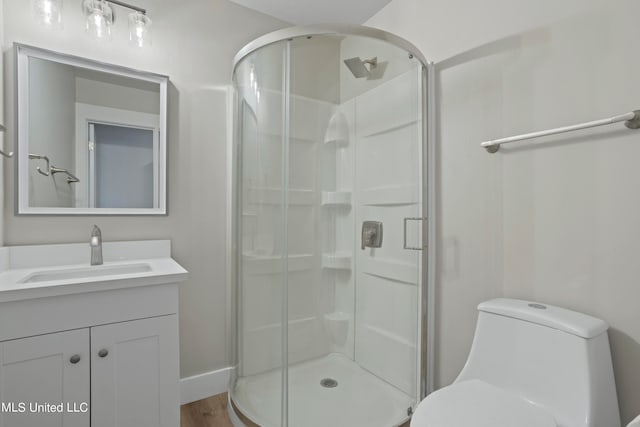 bathroom with vanity, toilet, walk in shower, and hardwood / wood-style floors