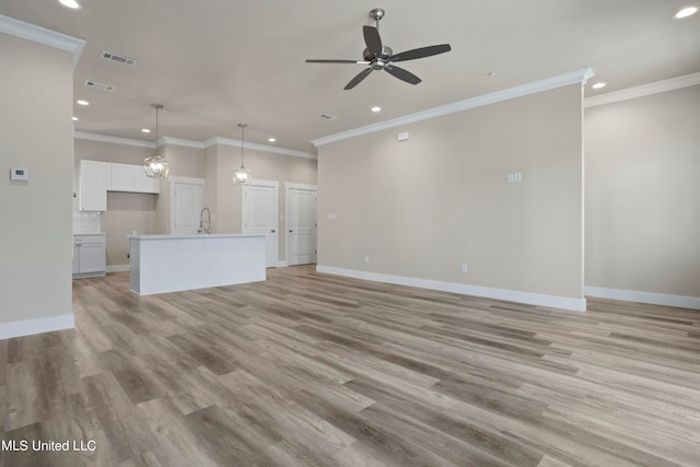 unfurnished living room featuring light hardwood / wood-style flooring, ceiling fan, and crown molding