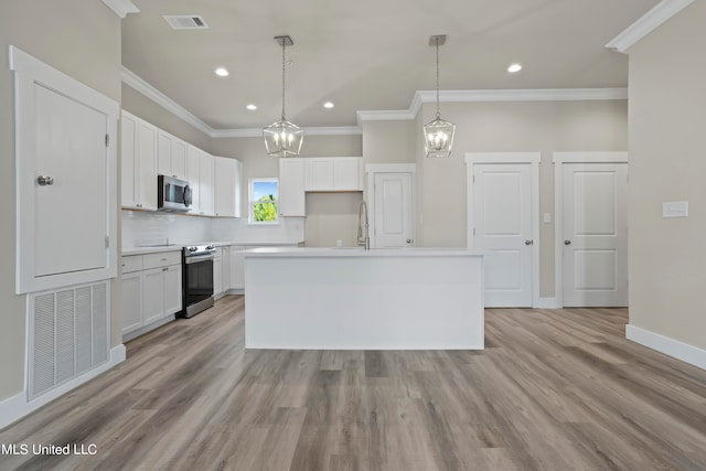 kitchen with white cabinets, hanging light fixtures, a kitchen island, light wood-type flooring, and stainless steel appliances