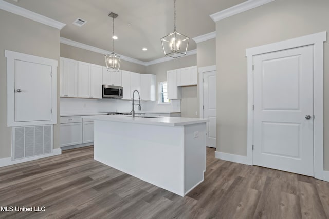 kitchen featuring pendant lighting, hardwood / wood-style flooring, an island with sink, and white cabinets