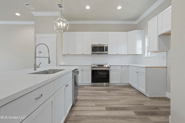 kitchen with sink, white cabinetry, light hardwood / wood-style flooring, and stainless steel appliances