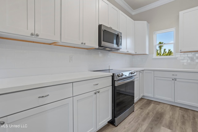 kitchen featuring white cabinetry, light hardwood / wood-style floors, appliances with stainless steel finishes, and decorative backsplash