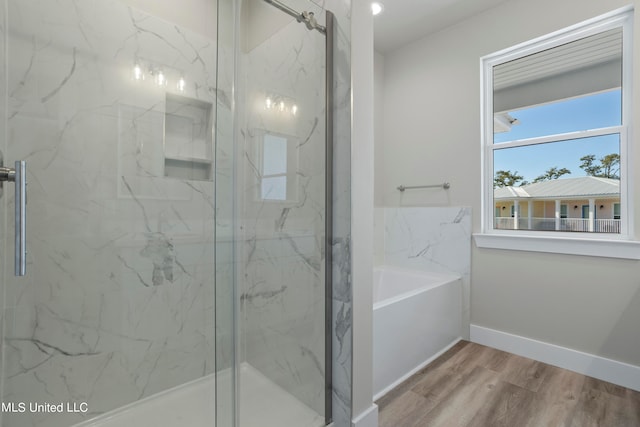 bathroom with shower with separate bathtub and wood-type flooring