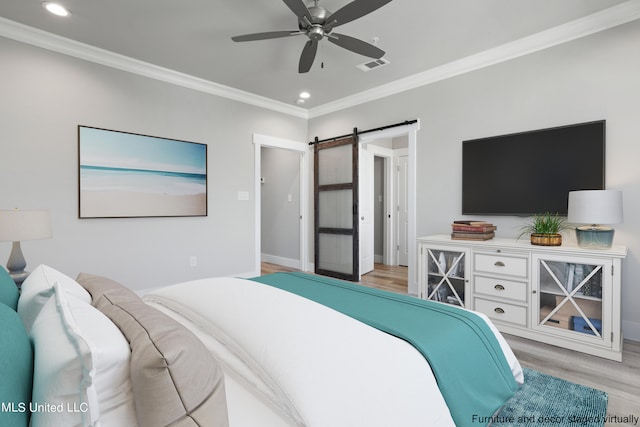 bedroom with light hardwood / wood-style flooring, ornamental molding, a barn door, and ceiling fan