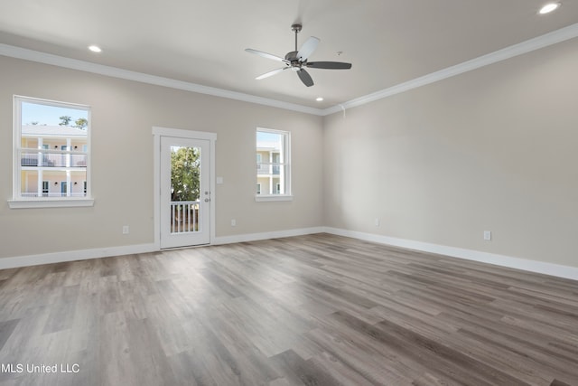 empty room featuring ornamental molding, wood-type flooring, and ceiling fan