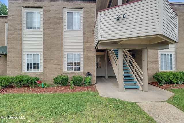 view of exterior entry featuring a lawn