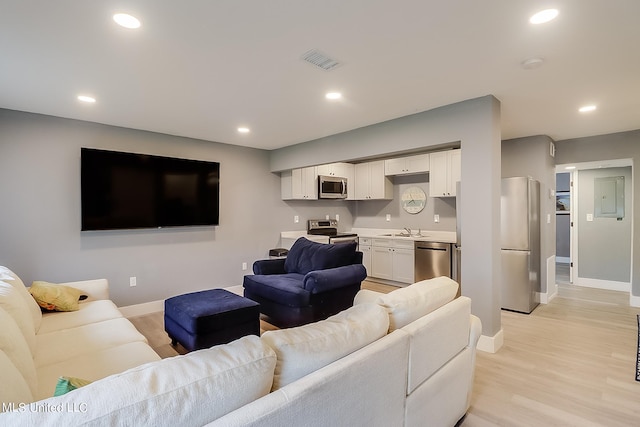 living room featuring sink and light hardwood / wood-style flooring