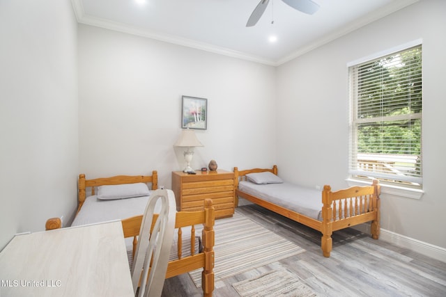 bedroom featuring ceiling fan, ornamental molding, and light wood-type flooring