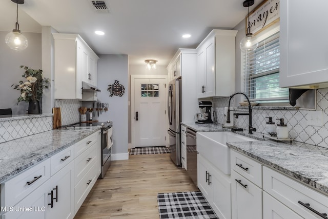 8707 Pine Ridge Ct, Diamondhead, MS 39525 - kitchen featuring appliances with stainless steel finishes, white cabinetry, backsplash, under cabinet range hood, and recessed lighting