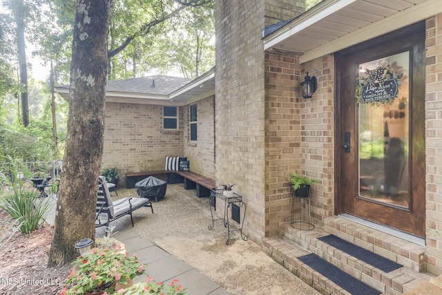 8707 Pine Ridge Ct, Diamondhead, MS 39525 - doorway to property with brick siding, roof with shingles, and a patio area