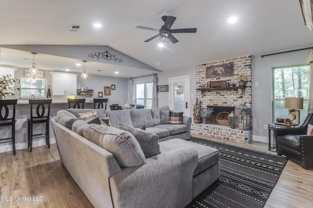 8707 Pine Ridge Ct, Diamondhead, MS 39525 - living room with wood finished floors, a ceiling fan, vaulted ceiling, a fireplace, and recessed lighting
