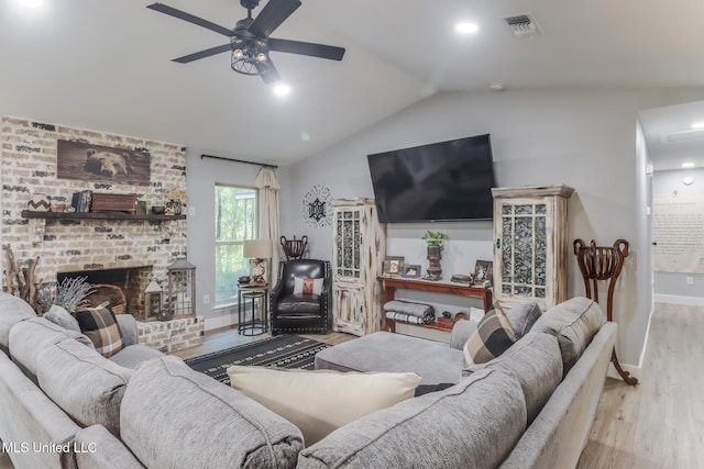 8707 Pine Ridge Ct, Diamondhead, MS 39525 - living room with wood finished floors, vaulted ceiling, a ceiling fan, and a brick fireplace