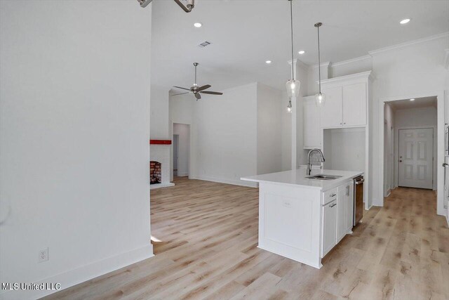 kitchen featuring white cabinetry, sink, hanging light fixtures, a kitchen island with sink, and ceiling fan