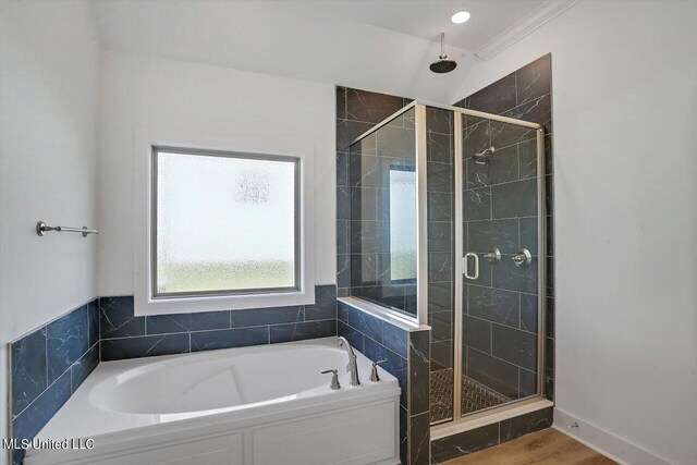 bathroom featuring hardwood / wood-style flooring, ornamental molding, and plus walk in shower