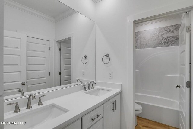 bathroom featuring toilet, ornamental molding, hardwood / wood-style flooring, and vanity