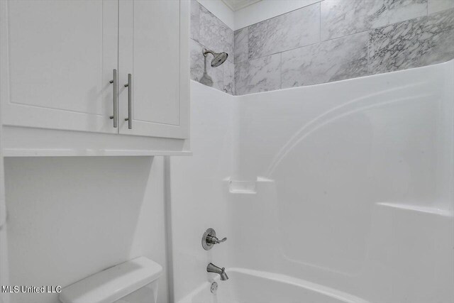 bathroom featuring toilet and bathing tub / shower combination