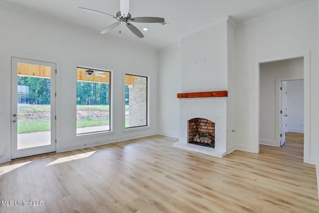 unfurnished living room featuring light wood-type flooring, ornamental molding, and a healthy amount of sunlight