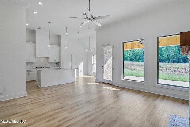 165 Cornerstone Dr, Brandon, MS 39042 - unfurnished living room featuring recessed lighting, a sink, light wood finished floors, and ceiling fan with notable chandelier