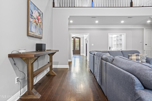 living area with baseboards, dark wood-style flooring, visible vents, and crown molding