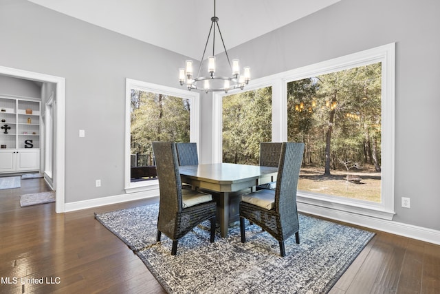 dining room featuring an inviting chandelier, baseboards, dark wood finished floors, and a wealth of natural light