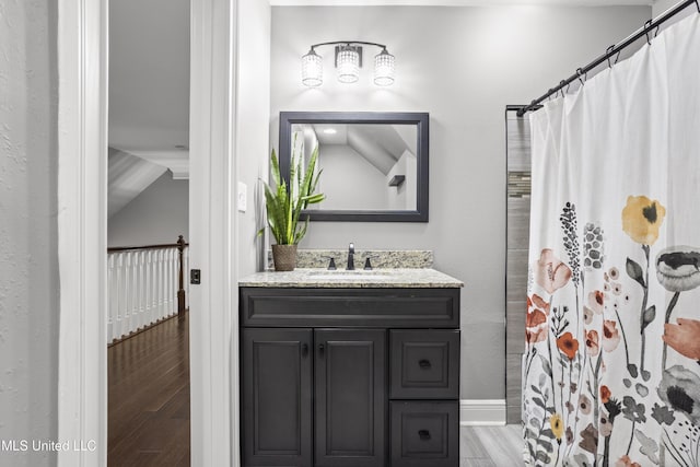 bathroom featuring curtained shower, wood finished floors, vanity, and baseboards