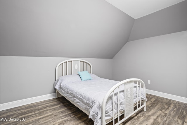 bedroom featuring lofted ceiling, wood finished floors, and baseboards