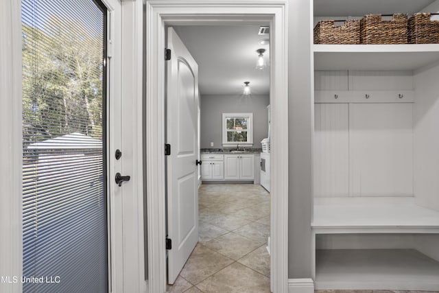 mudroom with light tile patterned flooring and a sink