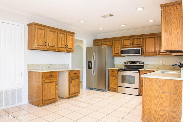 kitchen featuring sink, light tile patterned floors, ornamental molding, and appliances with stainless steel finishes