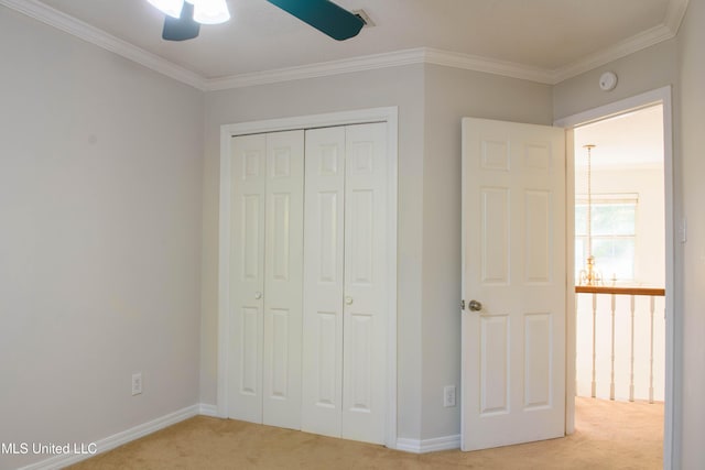 unfurnished bedroom with ceiling fan, ornamental molding, light carpet, and a closet