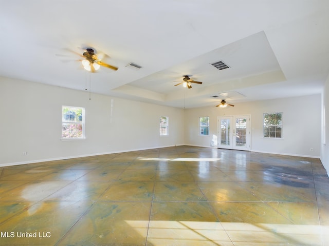 unfurnished room featuring french doors, a tray ceiling, and ceiling fan