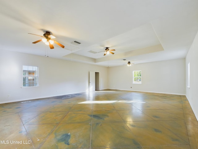 unfurnished room featuring a healthy amount of sunlight and a raised ceiling