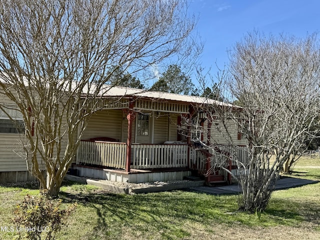 view of front of property with metal roof, a porch, and a front lawn