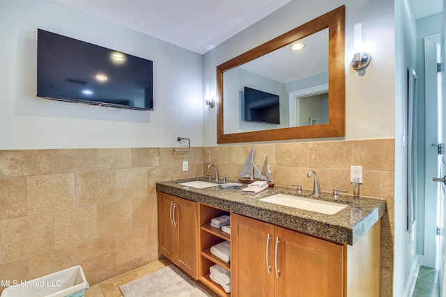 bathroom with double vanity, tile patterned floors, tile walls, and a sink