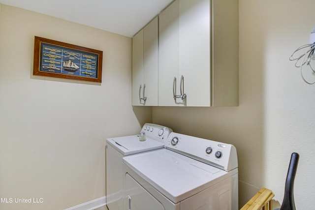 laundry room with baseboards, cabinet space, and washer and clothes dryer