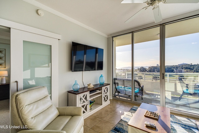 tiled living area featuring a ceiling fan, floor to ceiling windows, and crown molding