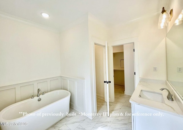 bathroom with vanity, a bath, and crown molding