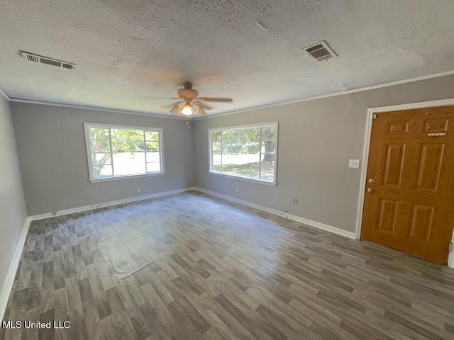 spare room with visible vents, wood finished floors, and ornamental molding