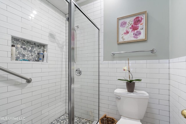 453 Cherry Tree Ln, Southaven, MS 38671 - bathroom featuring a stall shower, toilet, and tile walls