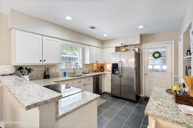 453 Cherry Tree Ln, Southaven, MS 38671 - kitchen with stainless steel appliances, a sink, a peninsula, white cabinets, and light stone counters
